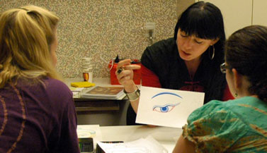 Carmen explaining how to draw the eye of the Buddha in the Tibetan tradition